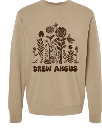 A beige crewneck sweatshirt with a graphic print of wildflowers and the text 'DREW ANGUS' on the front.